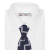 View 2 of product The Navy and White Striped Zigzag Silk Tie by Turnbull & Asser, shown rolled on a white background, features bold zigzag stripes—an ideal accessory for the modern gentleman’s everyday style.