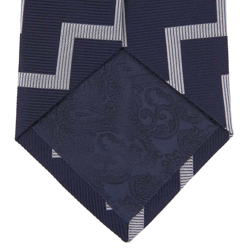 The Navy and White Striped Zigzag Silk Tie by Turnbull & Asser, shown rolled on a white background, features bold zigzag stripes—an ideal accessory for the modern gentleman’s everyday style.