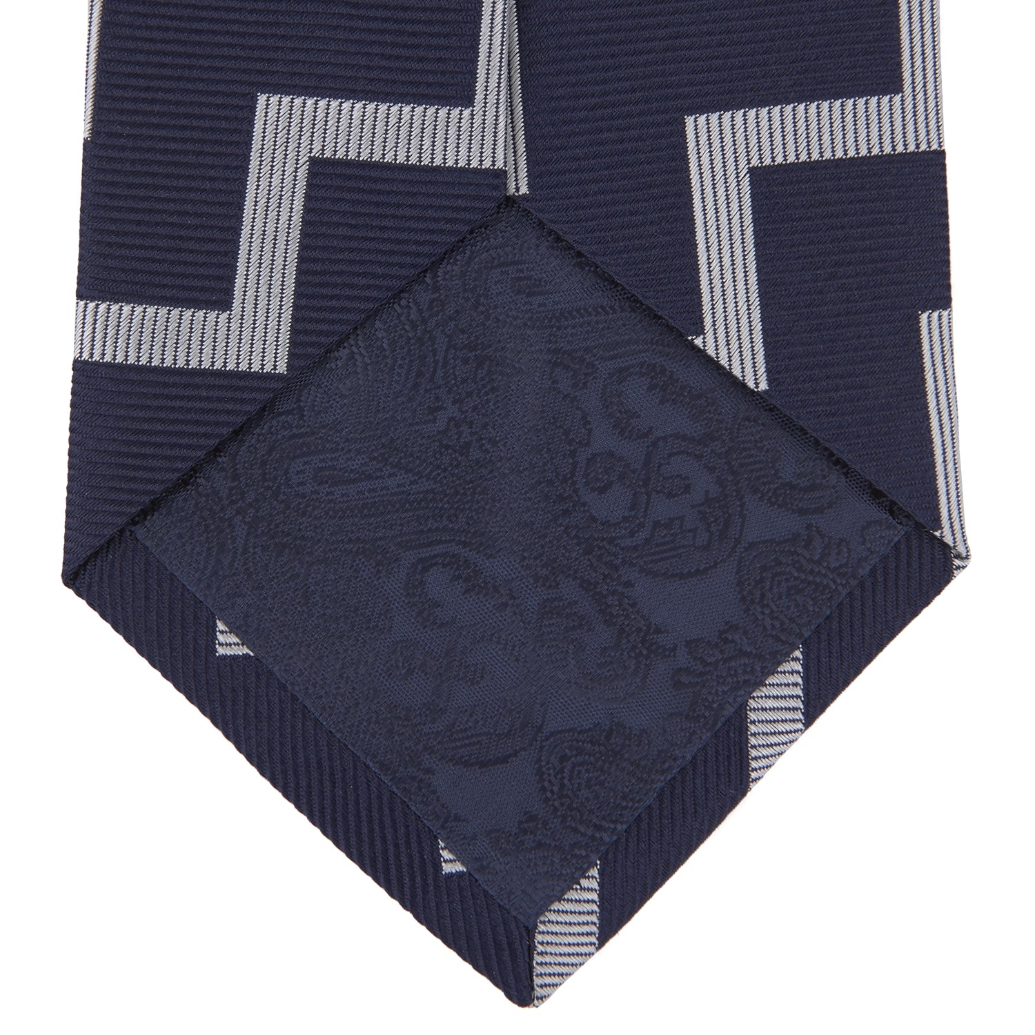 View 4 of product The Navy and White Striped Zigzag Silk Tie by Turnbull & Asser, shown rolled on a white background, features bold zigzag stripes—an ideal accessory for the modern gentleman’s everyday style.