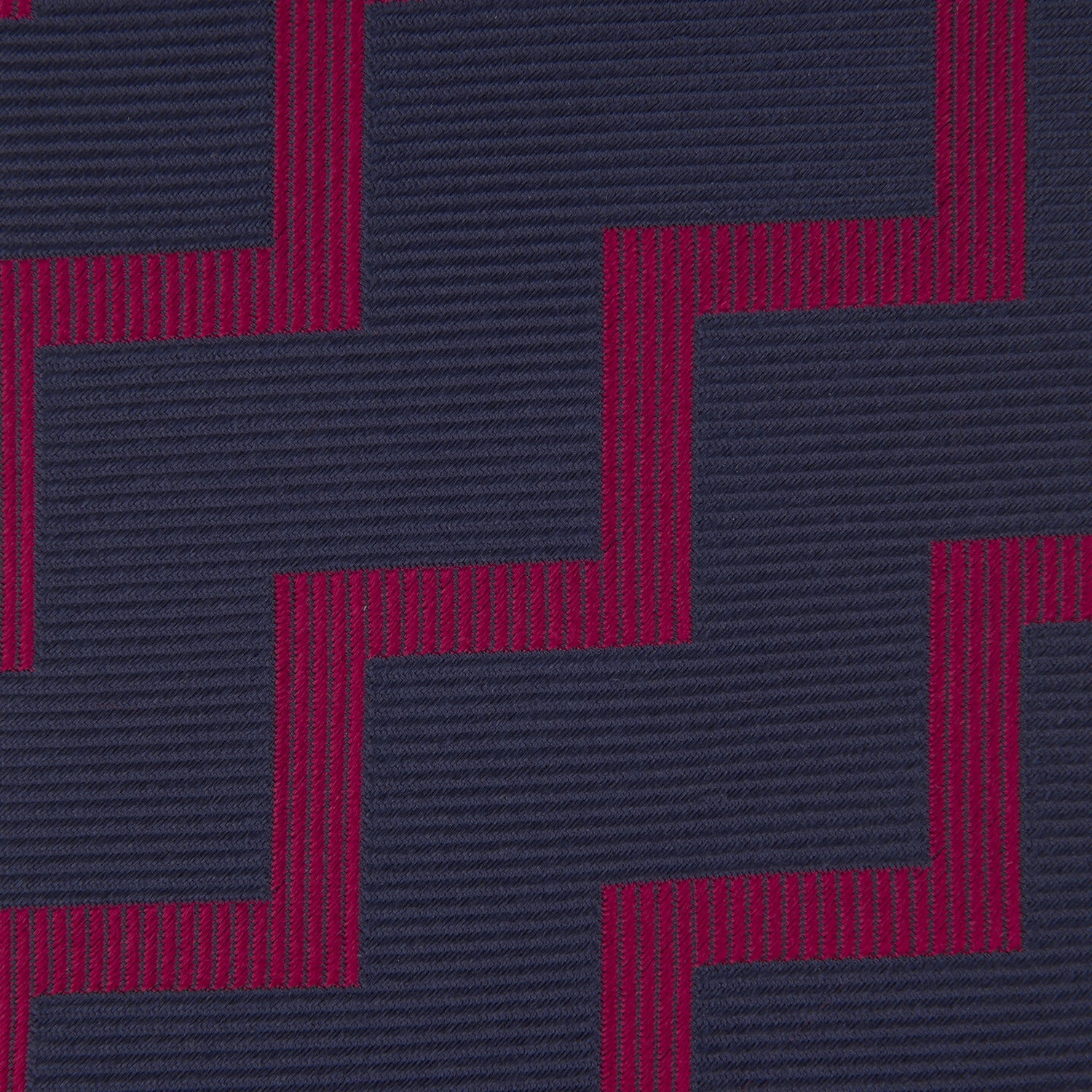 View 3 of product The Turnbull & Asser Navy and Red Striped Zigzag Silk Tie, featuring a striking pattern, is elegantly rolled on a white background—ideal for the modern gentleman.