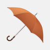 View 1 of product The Turnbull & Asser Orange Umbrella with Chestnut Crook features a vibrant canopy, elegant curved chestnut handle, and sturdy metal shaft, offering stylish weather protection. Displayed on a white background.