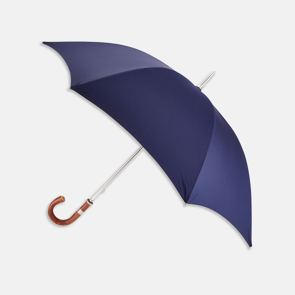 The Turnbull & Asser Navy Umbrella with Chestnut Crook features a curved wooden handle and silver metal shaft, designed for durability in English weather and shown against a plain white background.
