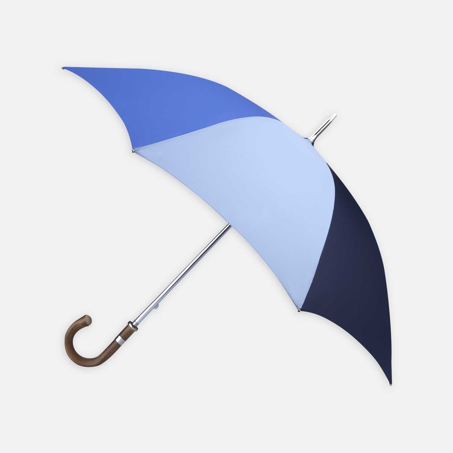 View 1 of product The Turnbull & Asser Sky, Royal Blue and Navy Umbrella with Chestnut Crook features alternating blue panels, a chestnut curved handle, and a silver shaft, making it stand out against a plain white background.