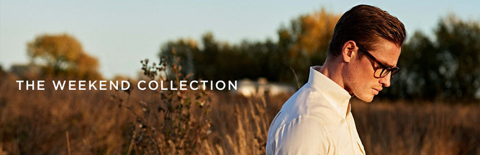 A man in glasses and a white shirt stands in a field at sunset. Text reads THE WEEKEND COLLECTION. Trees and grass are blurred in the background.