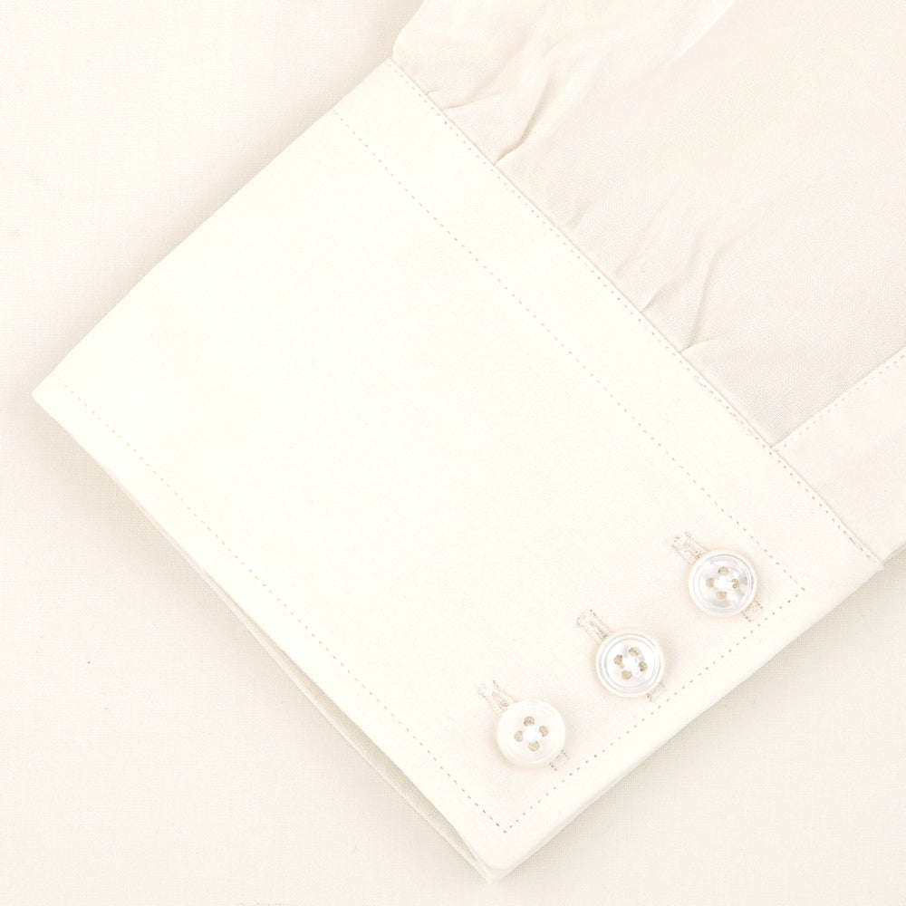 The Cream Silk Shirt by Turnbull & Asser features a T&A collar and 3-button cuffs, displayed folded on a light background—perfect for sophisticated evening wear.