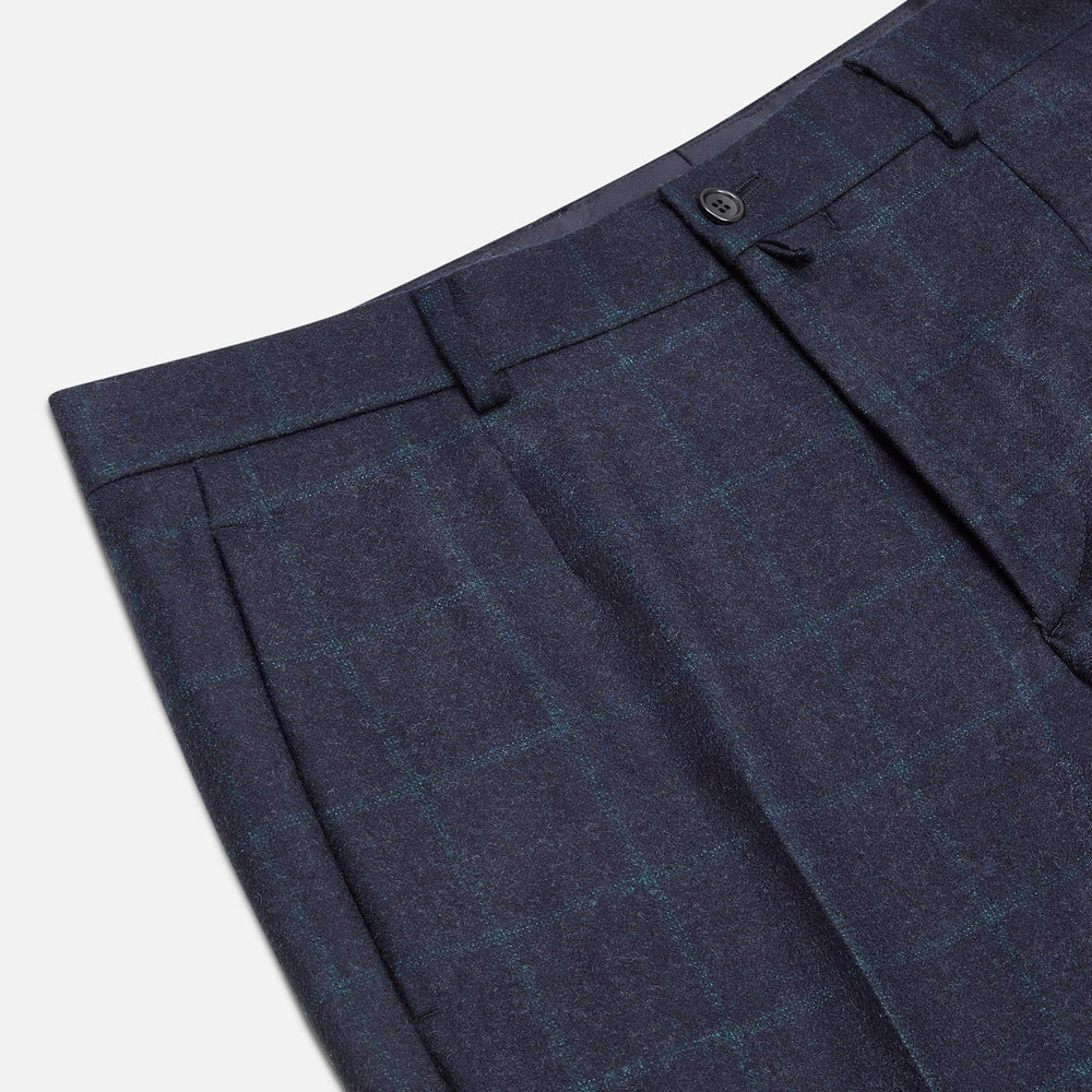 Turnbull & Asser’s Midnight and Green Check Rupert Trousers feature front pleats, belt loops, a button closure, and are finely crafted from wool and cashmere, shown against a plain white background.