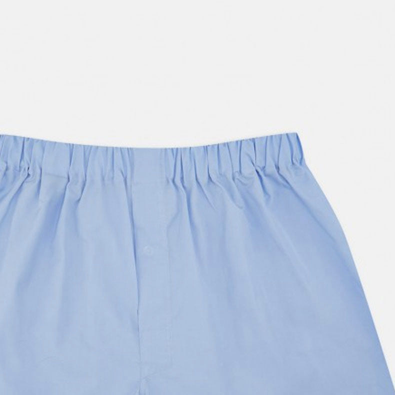 Turnbull & Asser's Plain Blue Cotton Boxer Shorts, shown flat against a white background, feature an elastic waistband—a stylish choice in men's underwear.
