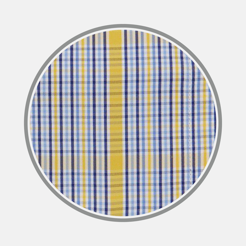 A close-up of Turnbull & Asser's Yellow & Blue Check Cotton Fabric shows its plaid pattern, with intersecting lines in yellow, blue, white, and light brown, displayed in a circular frame on a plain white background.