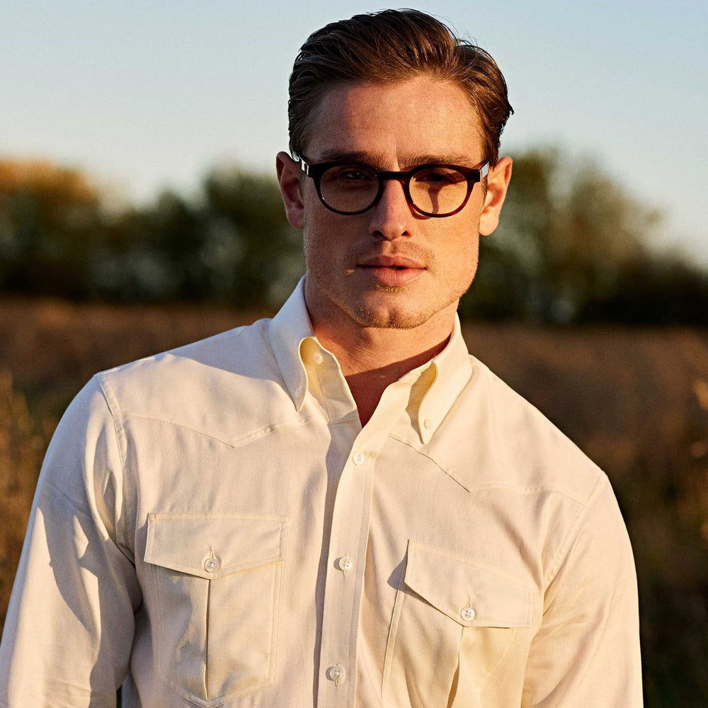 The Turnbull & Asser Weekend Fit Cream Herringbone Western Shirt features a Norfolk collar, button cuffs, and chest pockets, elegantly folded and displayed on a plain white background.