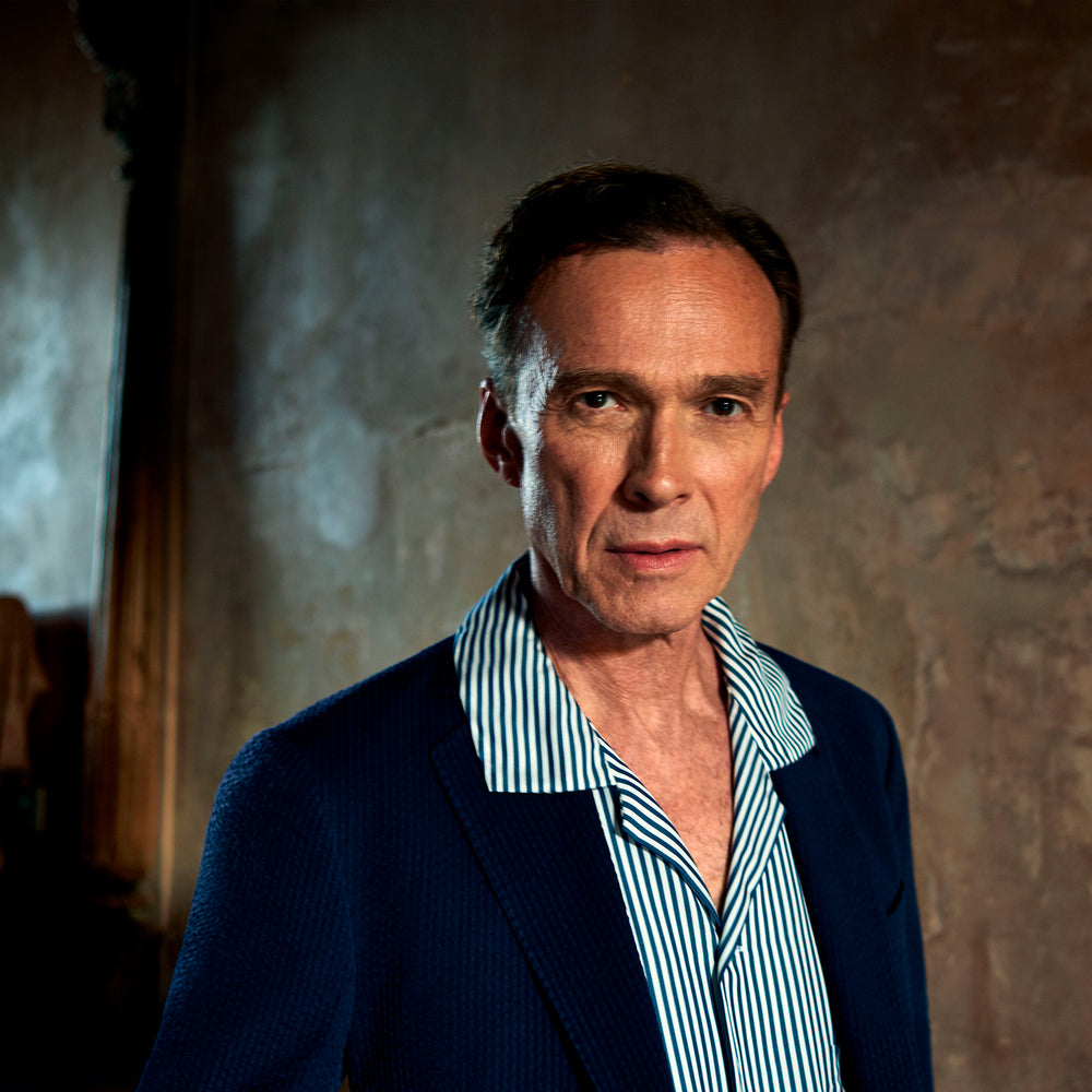 The Turnbull & Asser Navy & White Lyocell Stripe Holiday Fit Shirt is a short-sleeve button-up with a revere collar, vertical navy and white stripes, and a left chest pocket.