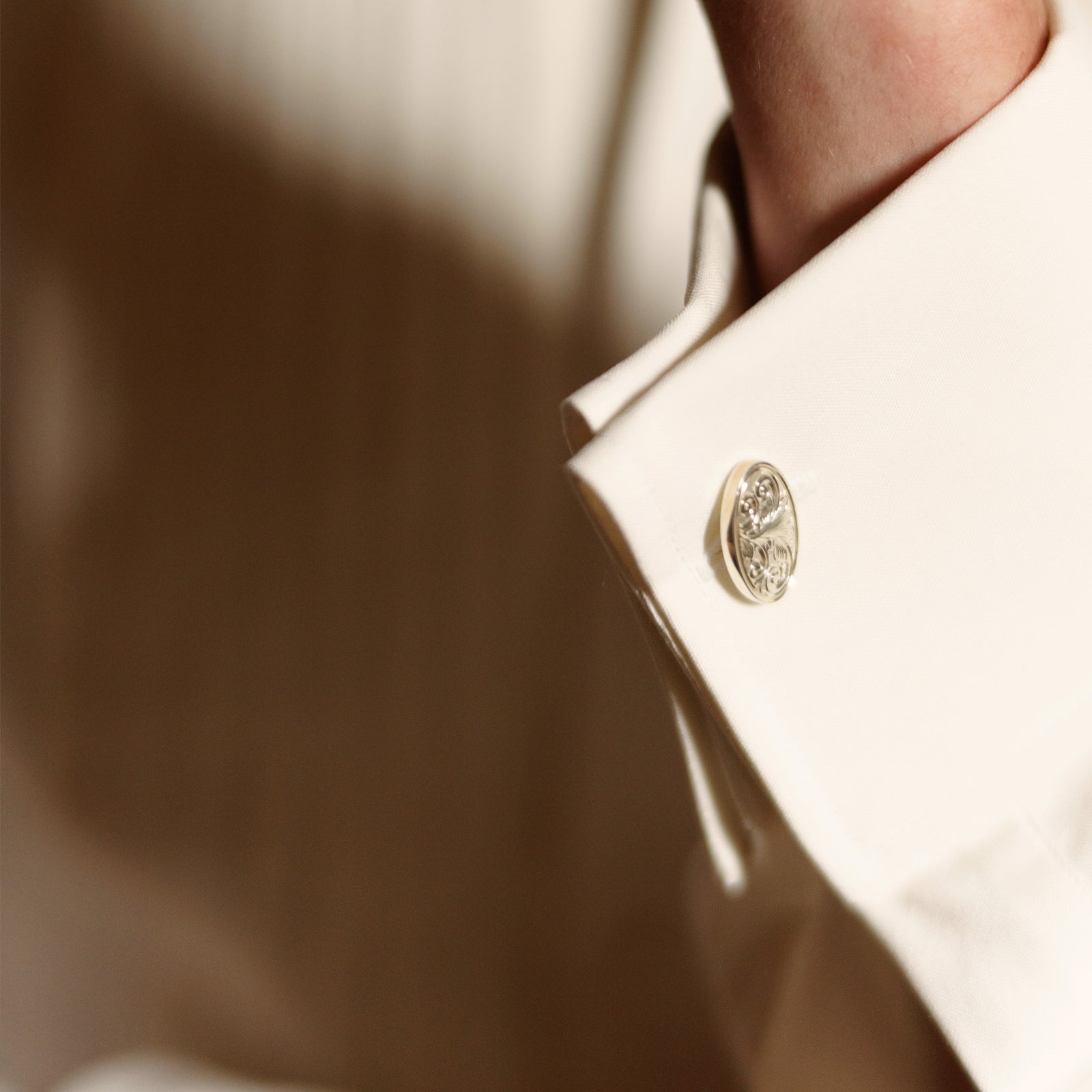 View 5 of product The Turnbull & Asser Tailored Fit Cream Pleated Front Silk Dress Shirt with T&A collar and double cuffs is displayed neatly folded against a light gray background.