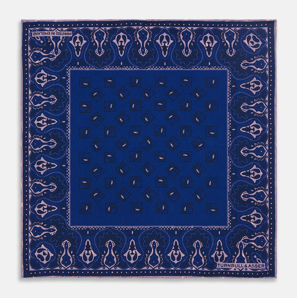 A pink and navy double-faced paisley silk bandana pocket square from Turnbull & Asser, featuring digitally printed designs with brand name in the corner.