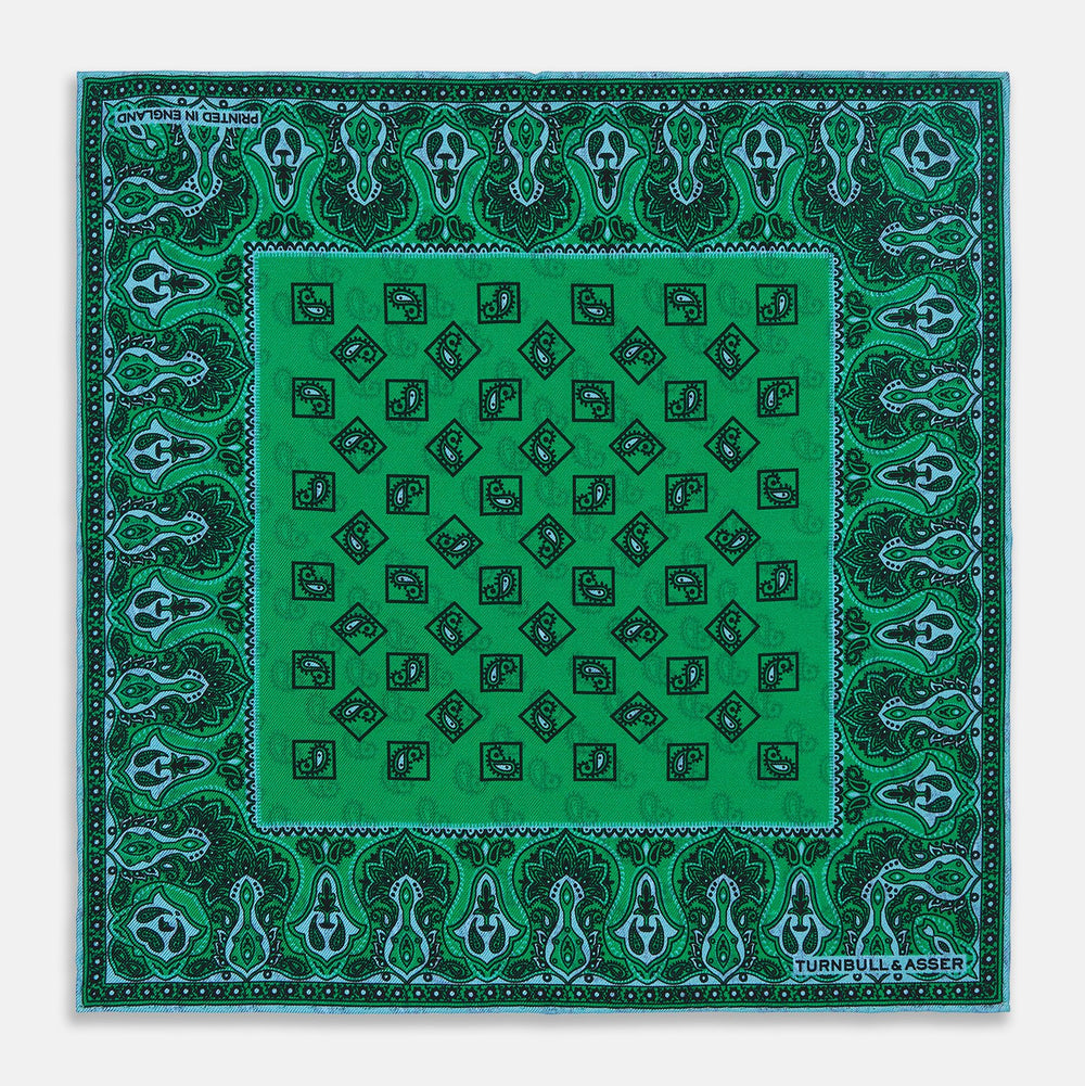 The Green & Blue Double-Faced Paisley Silk Bandana Pocket Square by Turnbull & Asser features a detailed paisley and geometric print with brand accents at the corners.