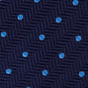 View 3 of product The Turnbull & Asser Seven-Fold Navy & Light Blue Spot Herringbone Silk Tie features a subtle herringbone weave with light blue polka dots, shown rolled up on a white background.