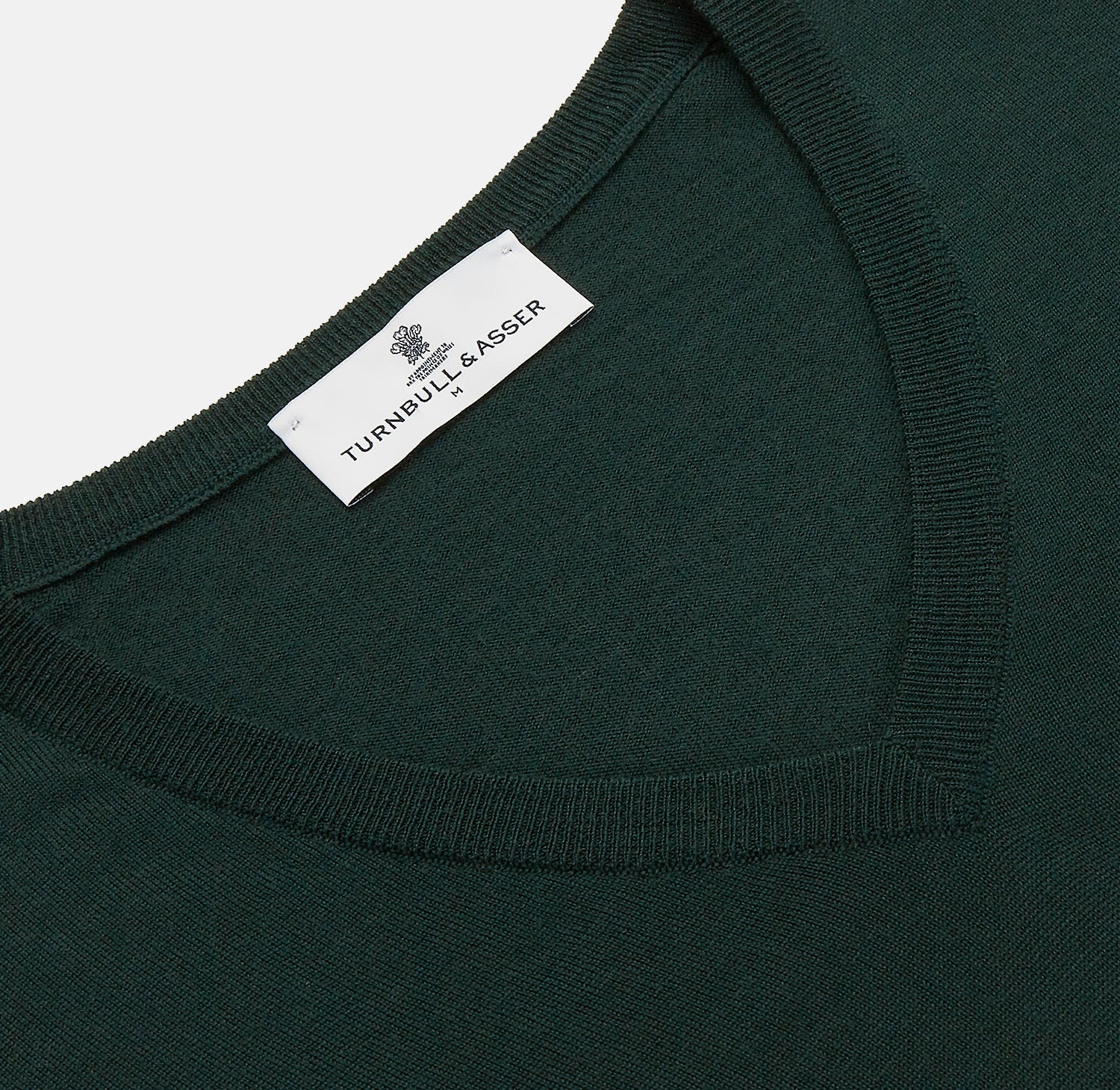 View 2 of product The Turnbull & Asser Forest Green Fine Merino V-Neck Jumper, shown laid flat on a white background, features classic Scottish knitwear details with ribbed cuffs and hem for a timeless look.