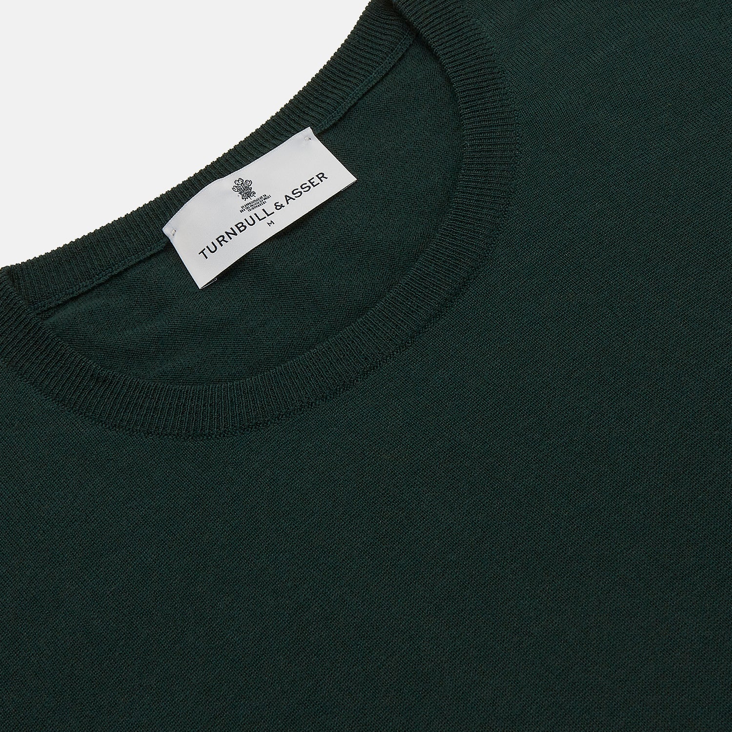 View 2 of product The Turnbull & Asser Forest Green Crew Neck Merino Jumper features ribbed cuffs and hem for a classic look. Laid flat on a white background, this luxury long-sleeve sweater is an essential, timeless addition to any wardrobe.