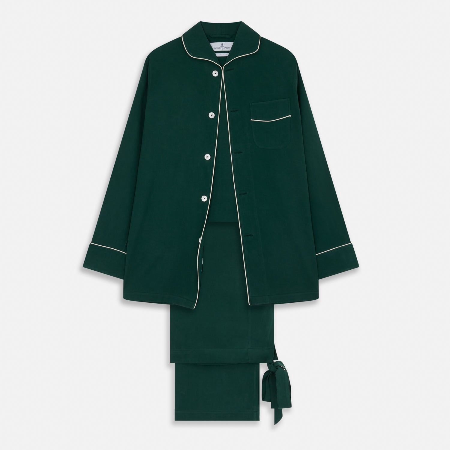 View 1 of product The Turnbull & Asser Dark Green Silk Pyjama Set features a long-sleeve button-up top with white piping, chest pocket, and matching pants, all neatly folded on a plain white background.