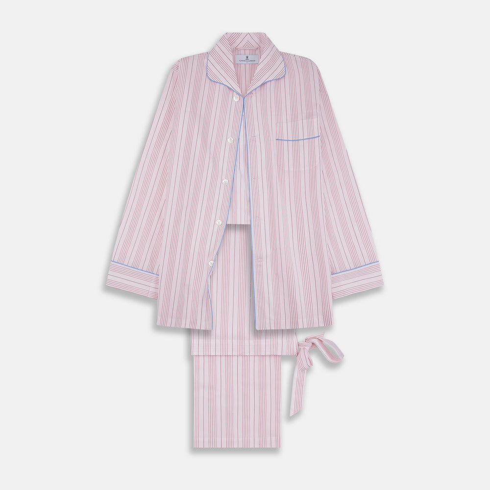 The Turnbull & Asser Pink And White Stripe Twill Cotton Pyjama Set features long sleeves and pants with a curved collar and blue trim on the cuffs, pocket, and hem—a classic gent’s style shown on a plain white background.