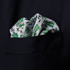 View 2 of product The Turnbull & Asser Green Dressing Gowns Pocket Square features a white silk base with green lines and a repeating pattern of green and black illustrated golfers, inspired by classic Turnbull dressing gown designs.