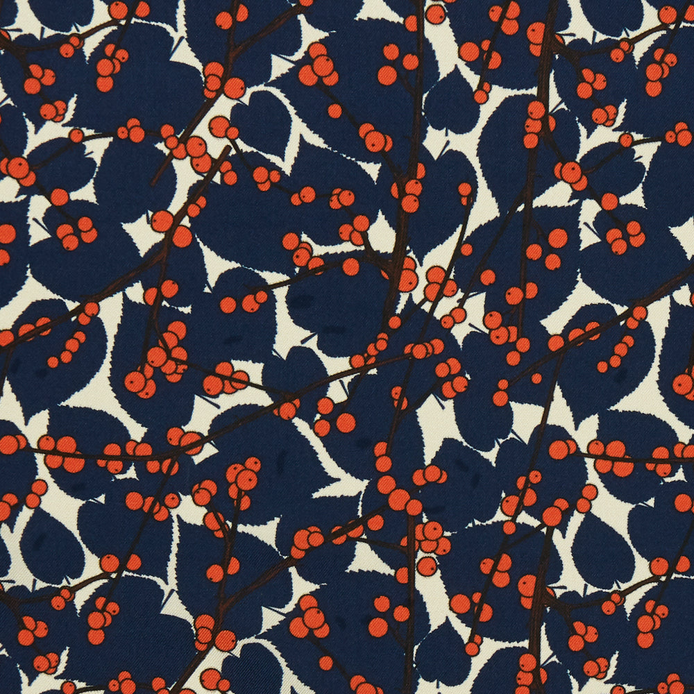 The Blue Berry Floral Pocket Square by Turnbull & Asser features a navy blue silk background with red berry and white leaf designs, plus small labels on two corners—making it a perfect festive gift.