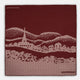 The Burgundy Snowscape Motif Silk Extra Large Scarf by Turnbull & Asser features a hand-rolled edge and a pink cross-stitch village scene—houses, church, hills—printed in England. A refined winter accessory.