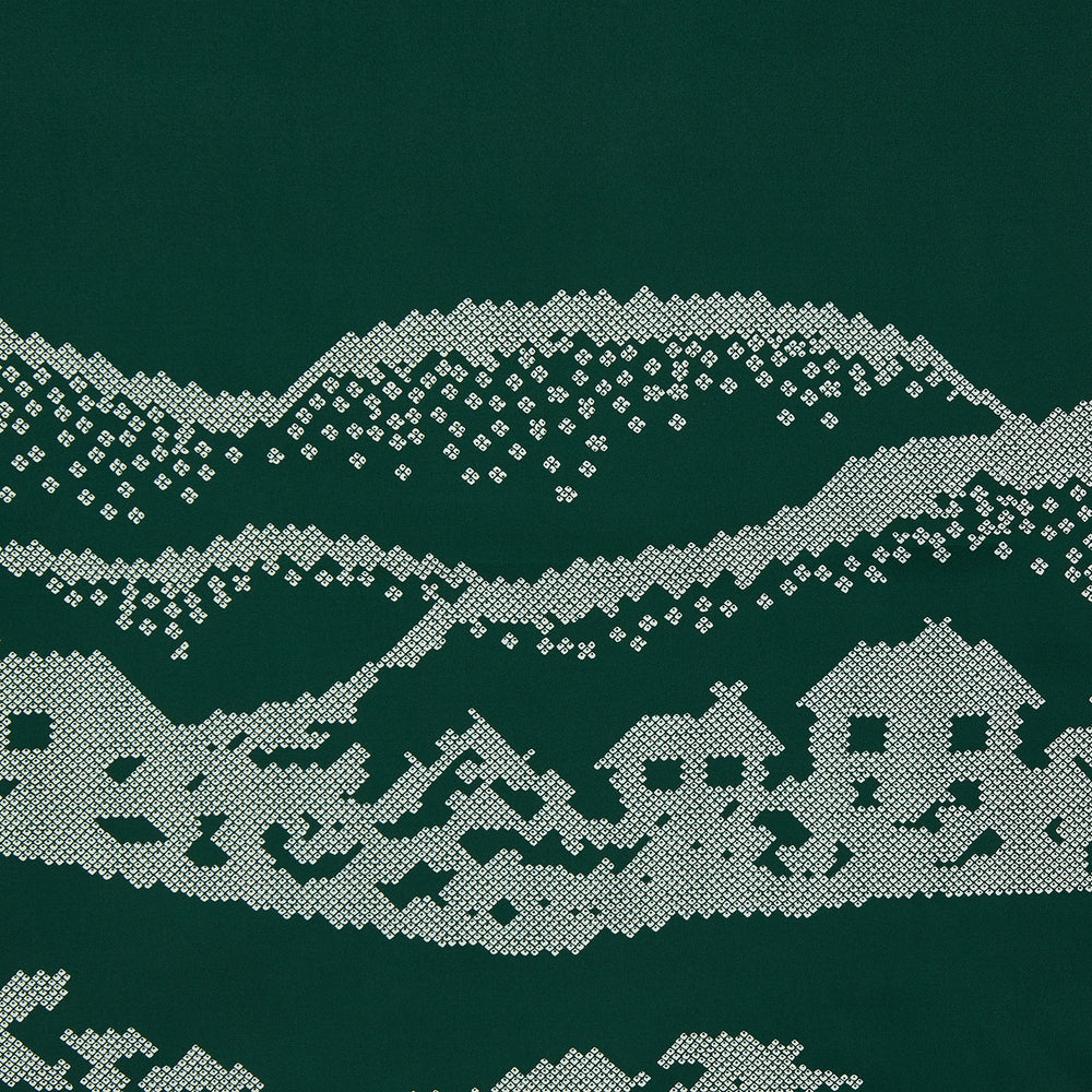 The Green Snowscape Motif Silk Extra Large Scarf by Turnbull & Asser features a white embroidered winter landscape with hills, trees, a church, and houses. "TURNBULL AND ASSER" appears in the corner. Made in England—perfect for winter.