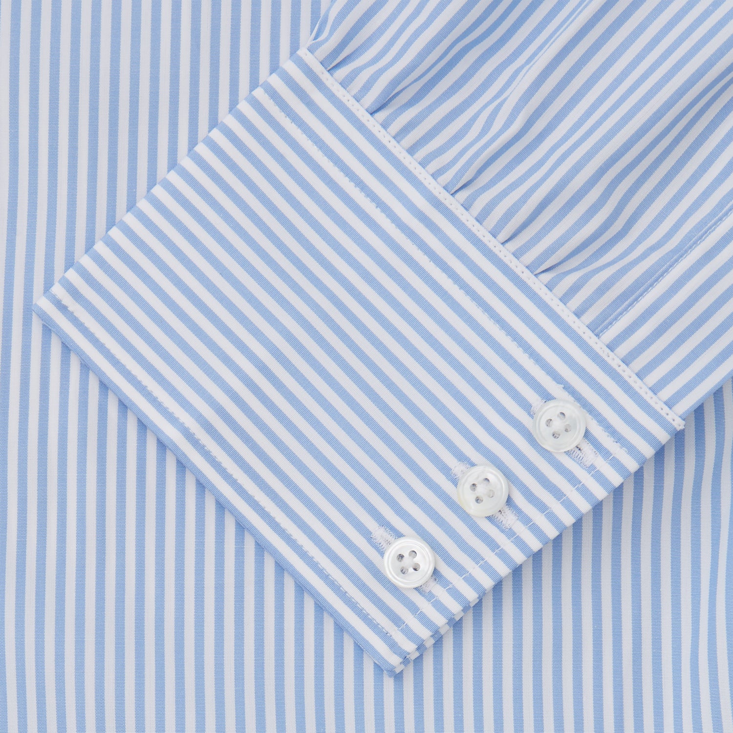 View 3 of product The Turnbull & Asser Light Blue Bengal Stripe Shirt features white vertical stripes, a classic T&A collar, and 3-button cuffs. Buttoned down the front, it’s laid flat on a white background for a timeless British look.