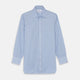 The Turnbull & Asser Light Blue Bengal Stripe Shirt features white vertical stripes, a classic T&A collar, and 3-button cuffs. Buttoned down the front, it’s laid flat on a white background for a timeless British look.