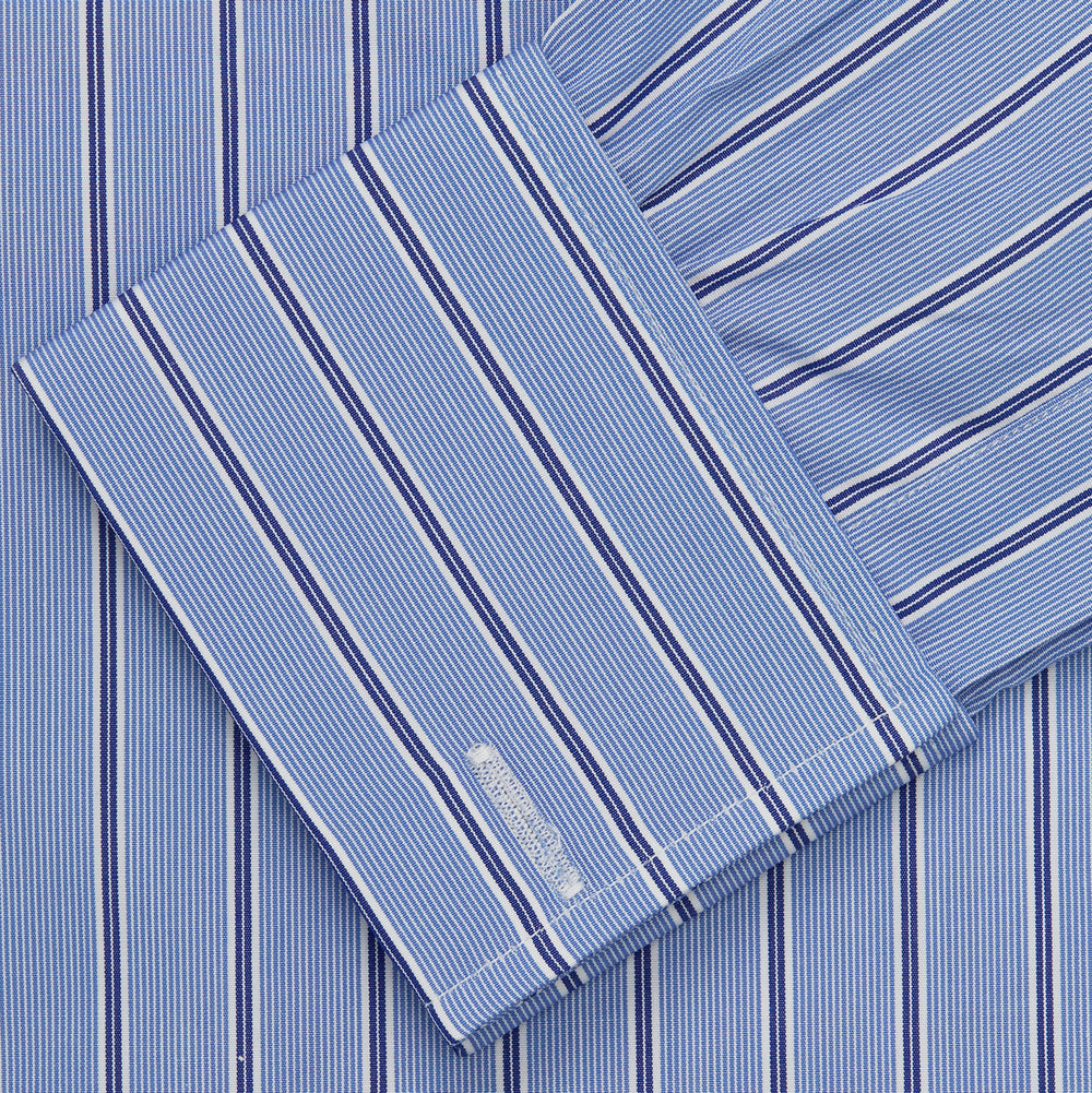 A neatly folded Turnbull & Asser Blue Stripe Regular Fit Shirt with T&A collar and square double cuffs, featuring long sleeves and thin white stripes on a light blue base, displayed on a plain white background.