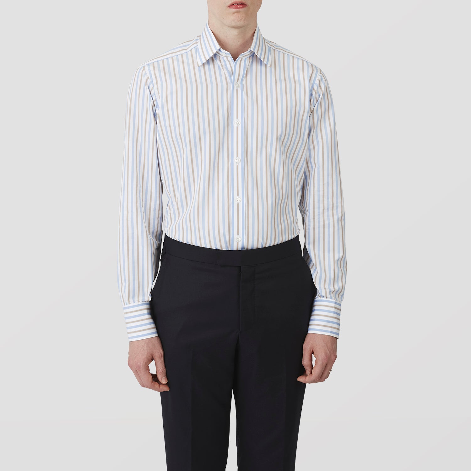 View 2 of product The Turnbull & Asser Blue and Brown Stripe Poplin Shirt features a T&A collar, three-button cuffs, and vertical blue, white, and tan stripes. This smart-casual shirt is displayed on a plain light background.
