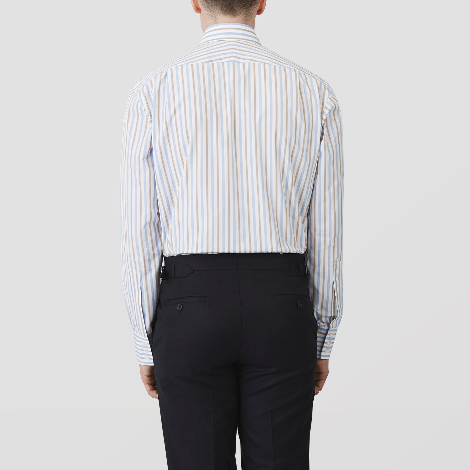View 3 of product The Turnbull & Asser Blue and Brown Stripe Poplin Shirt features a T&A collar, three-button cuffs, and vertical blue, white, and tan stripes. This smart-casual shirt is displayed on a plain light background.
