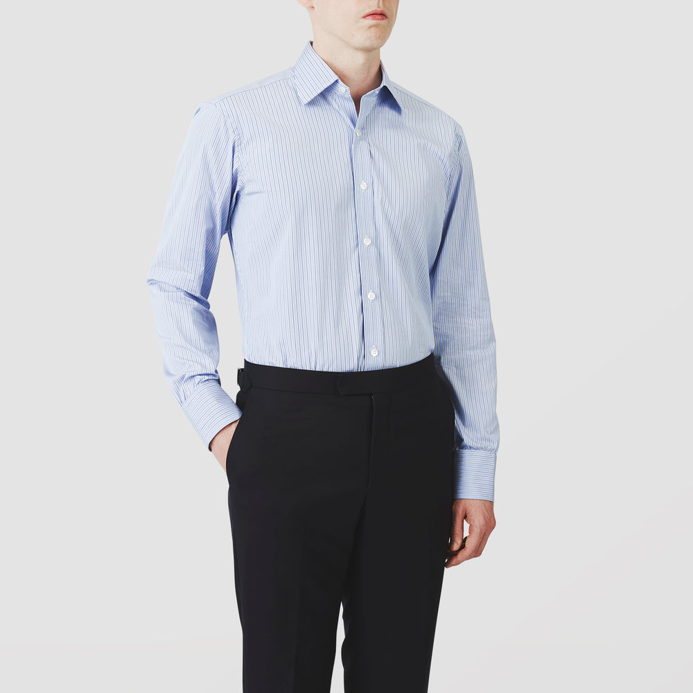 Turnbull & Asser’s Blue Stripe Shirt features thin vertical white stripes, a T&A collar, 3-button cuffs, white buttons, and a regular fit. Smart-casual style displayed flat on a white background.