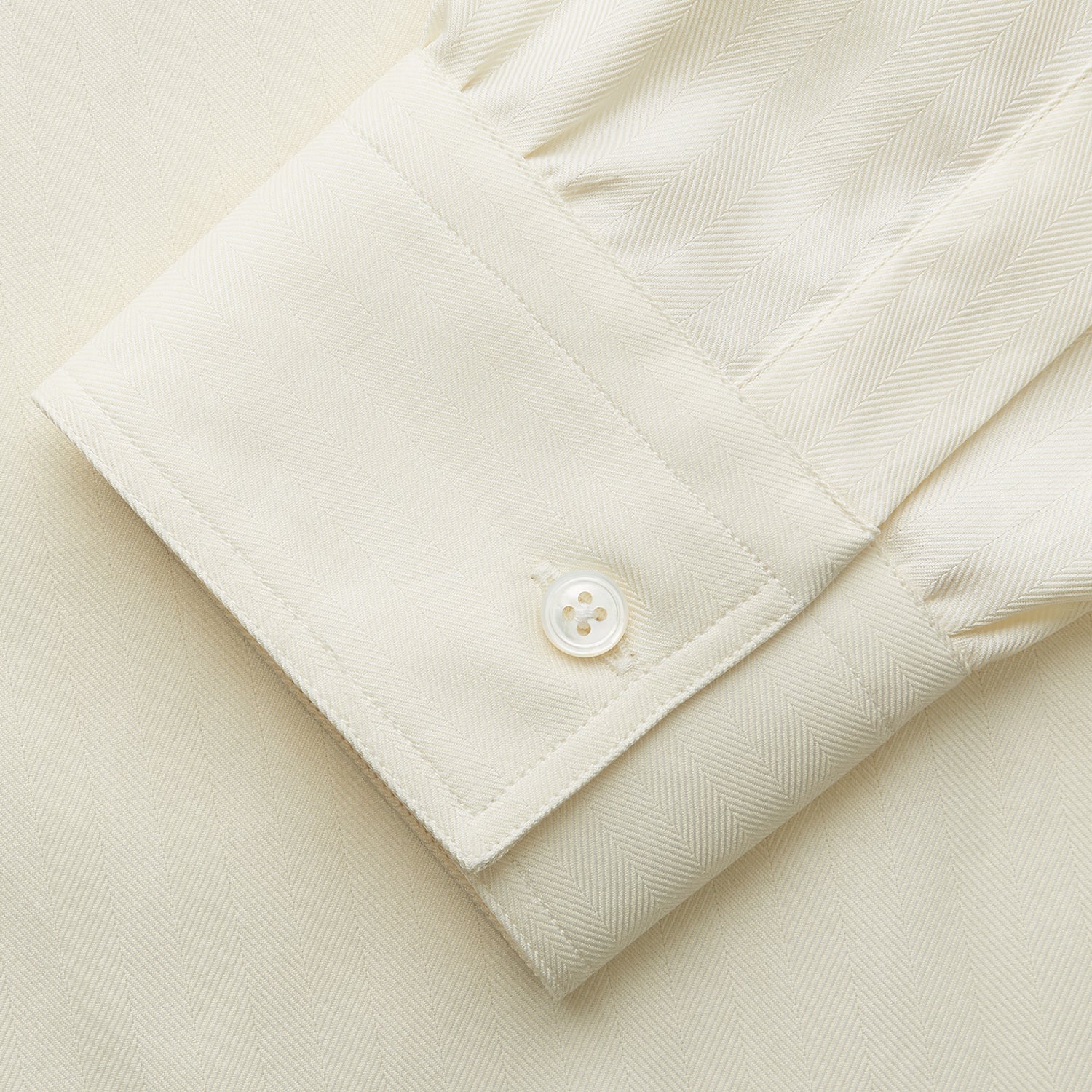 View 3 of product The Cream Herringbone Fine Cotton Weekend Officer Fit Shirt by Turnbull & Asser features a Dorset collar, long sleeves, two button-flap chest pockets, and buttoned cuffs—perfect for smart-casual style.