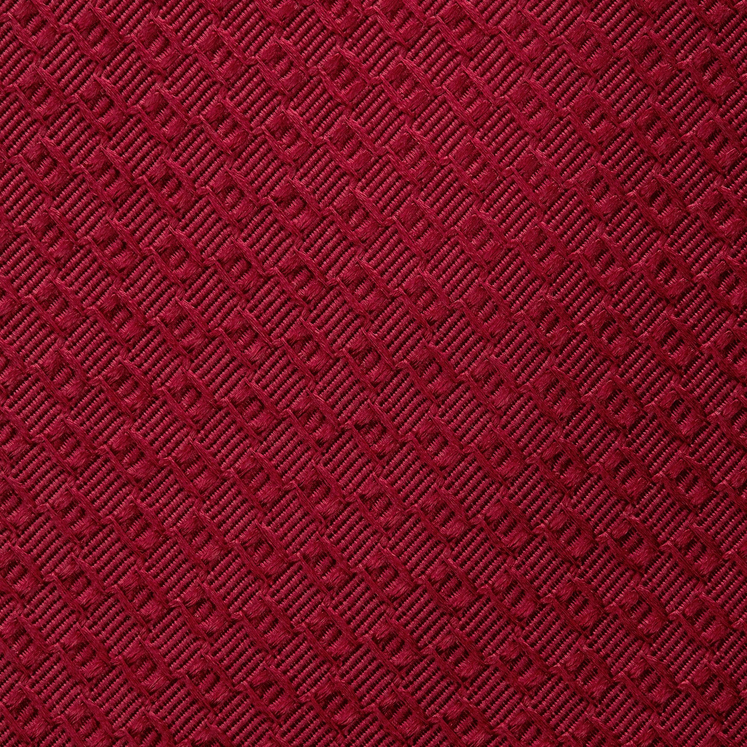 View 3 of product The Turnbull & Asser Burgundy Abstract Tonal Silk Jacquard Tie is shown rolled up with a subtle textured pattern on a plain white background—an elegant formalwear choice.