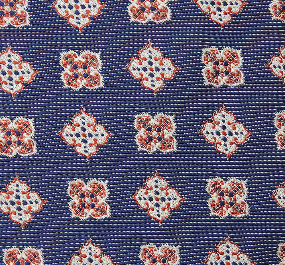 The Turnbull & Asser Burgundy Geometric Jacquard Tie features a bold, playful pattern of red and white dice scattered across its surface.