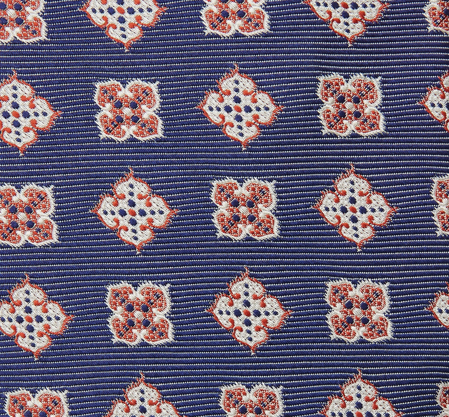 View 3 of product The Turnbull & Asser Burgundy Geometric Jacquard Tie features a bold, playful pattern of red and white dice scattered across its surface.