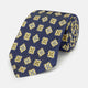 The Turnbull & Asser Yellow Geometric Jacquard Tie in navy features a repeating pattern of yellow geometric shapes with blue accents, presented rolled up on a white background.