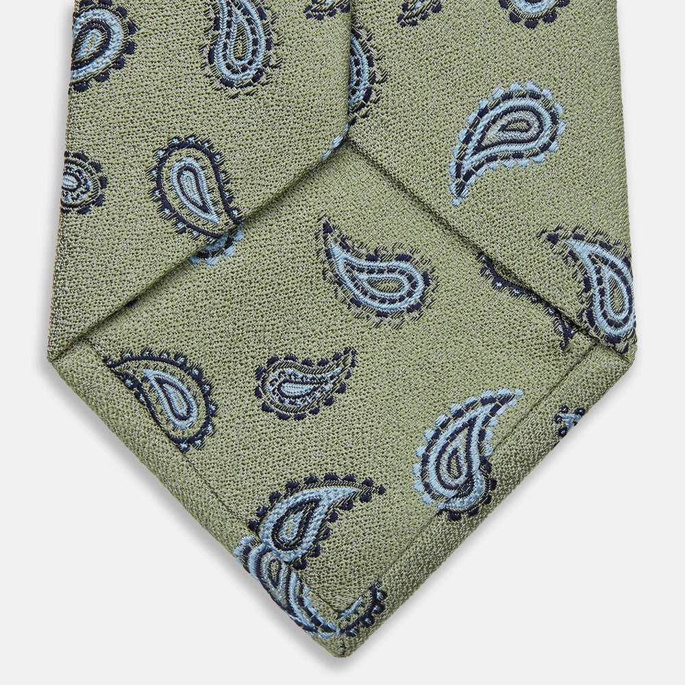 The Green Renoir Paisley Tie by Turnbull & Asser is a pistachio green jacquard tie with blue and black paisley motifs on a light background.