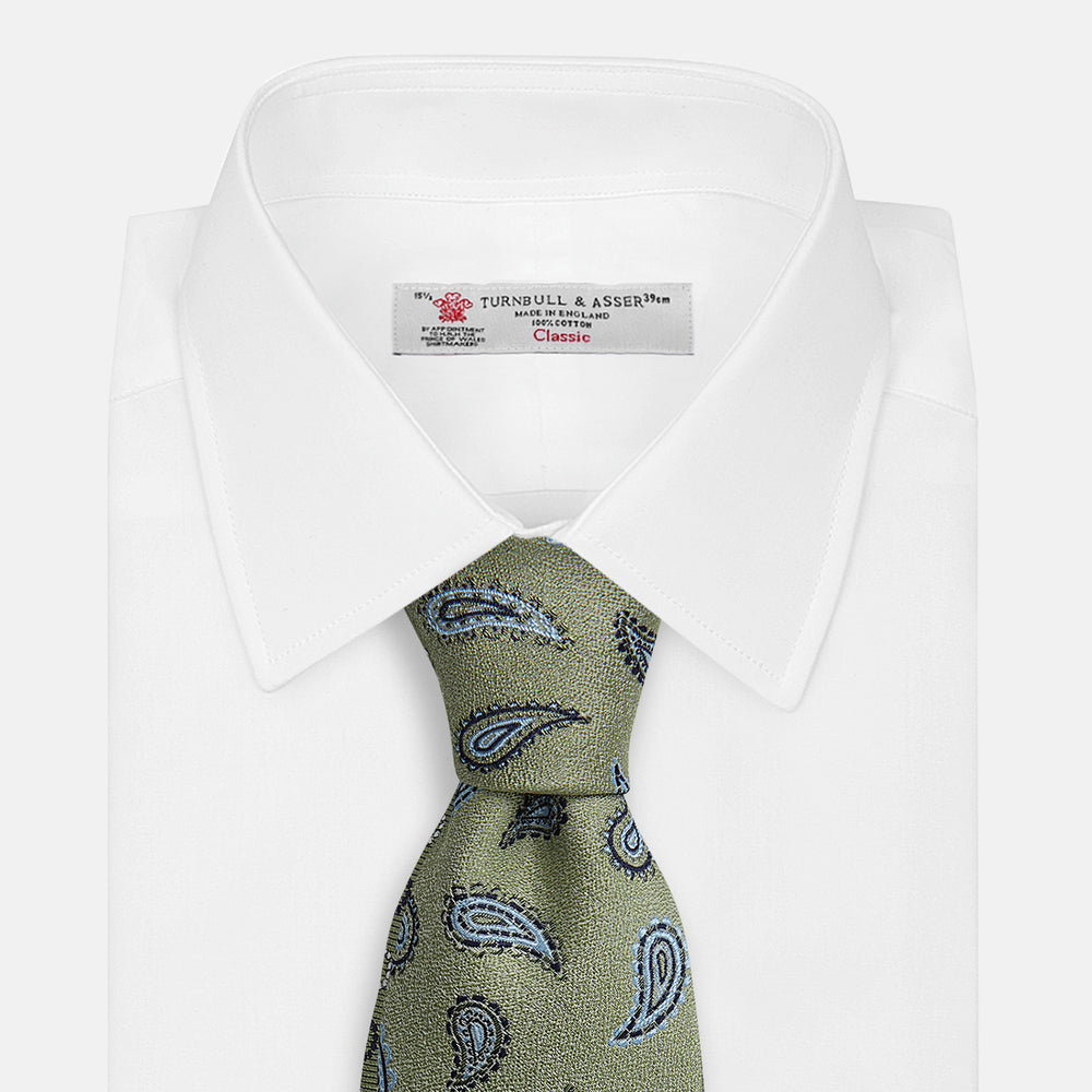 The Green Renoir Paisley Tie by Turnbull & Asser is a pistachio green jacquard tie with blue and black paisley motifs on a light background.