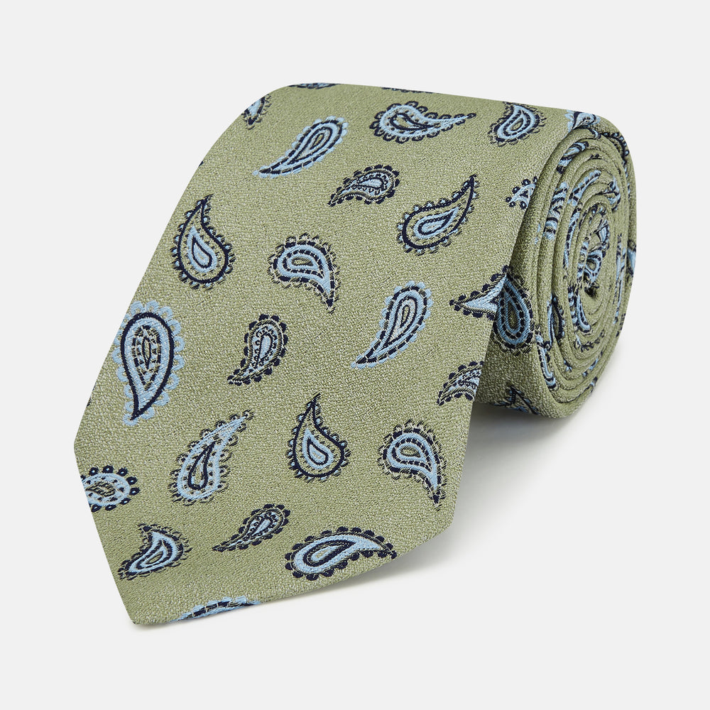 The Green Renoir Paisley Tie by Turnbull & Asser is a pistachio green jacquard tie with blue and black paisley motifs on a light background.