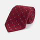 The Turnbull & Asser Red Square Silk Tie features a red and blue pattern with small white squares, elegantly rolled and displayed on a plain white background—a refined choice for men's accessories.