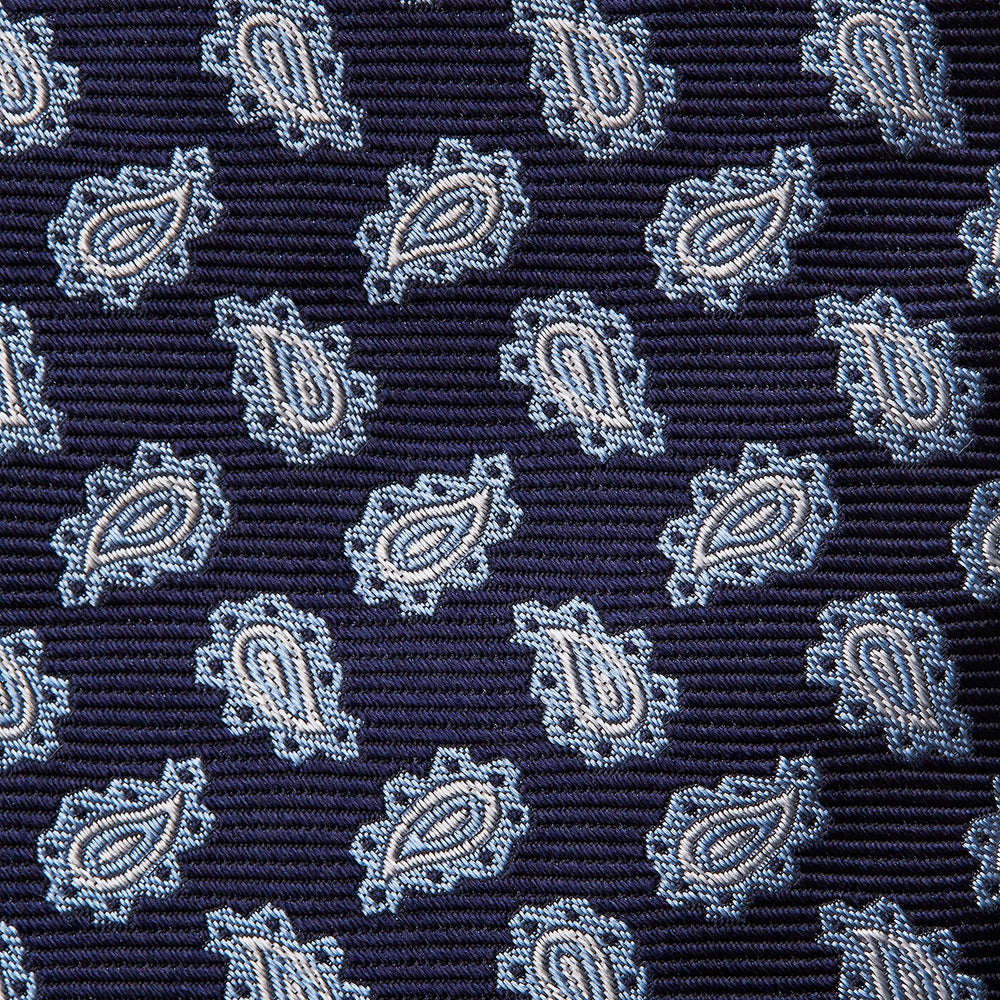 The Blue Abstract Paisley Silk Tie by Turnbull & Asser features a classic paisley motif in navy, offering a timeless touch to your wardrobe and perfectly capturing traditional elegance.
