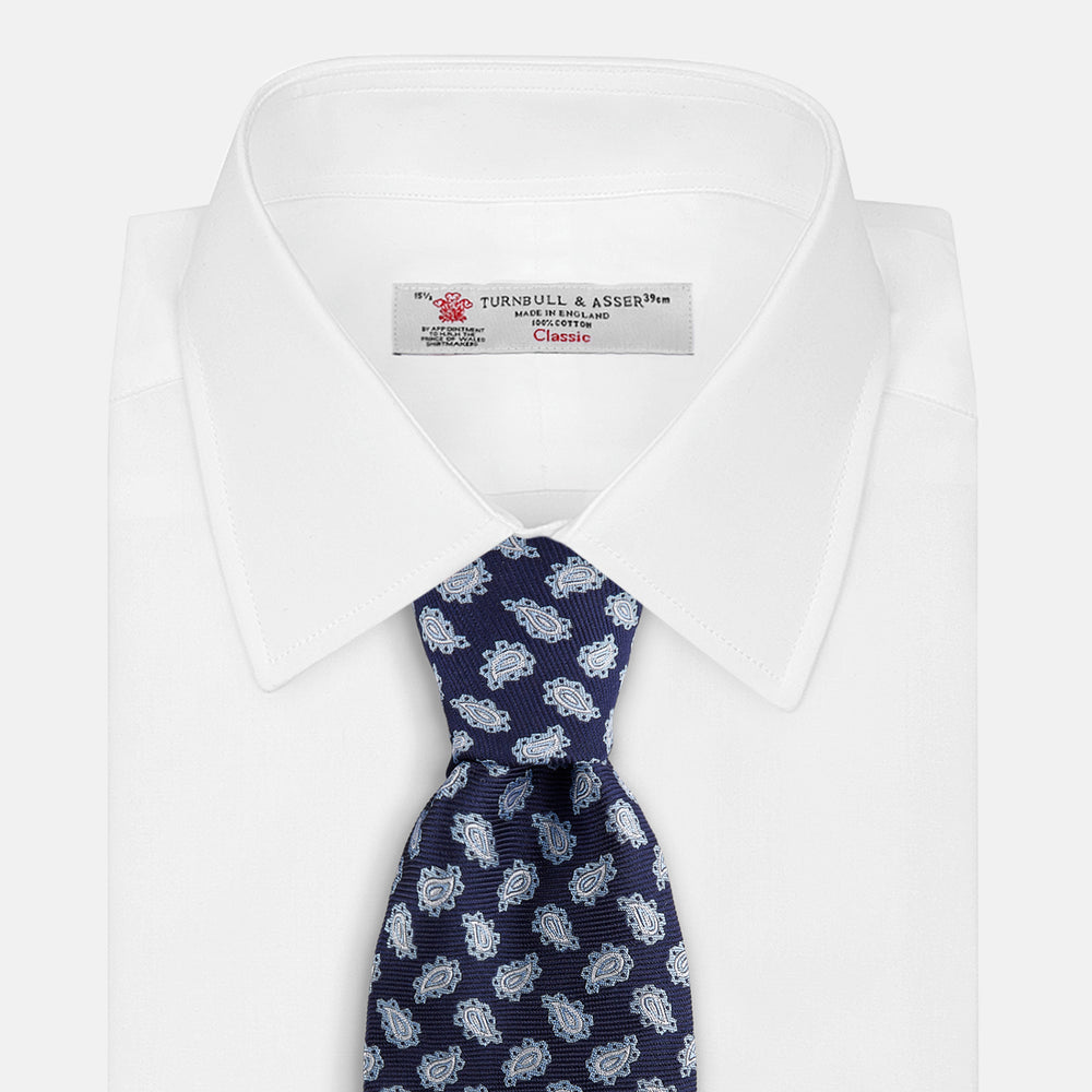 The Blue Abstract Paisley Silk Tie by Turnbull & Asser features a classic paisley motif in navy, offering a timeless touch to your wardrobe and perfectly capturing traditional elegance.