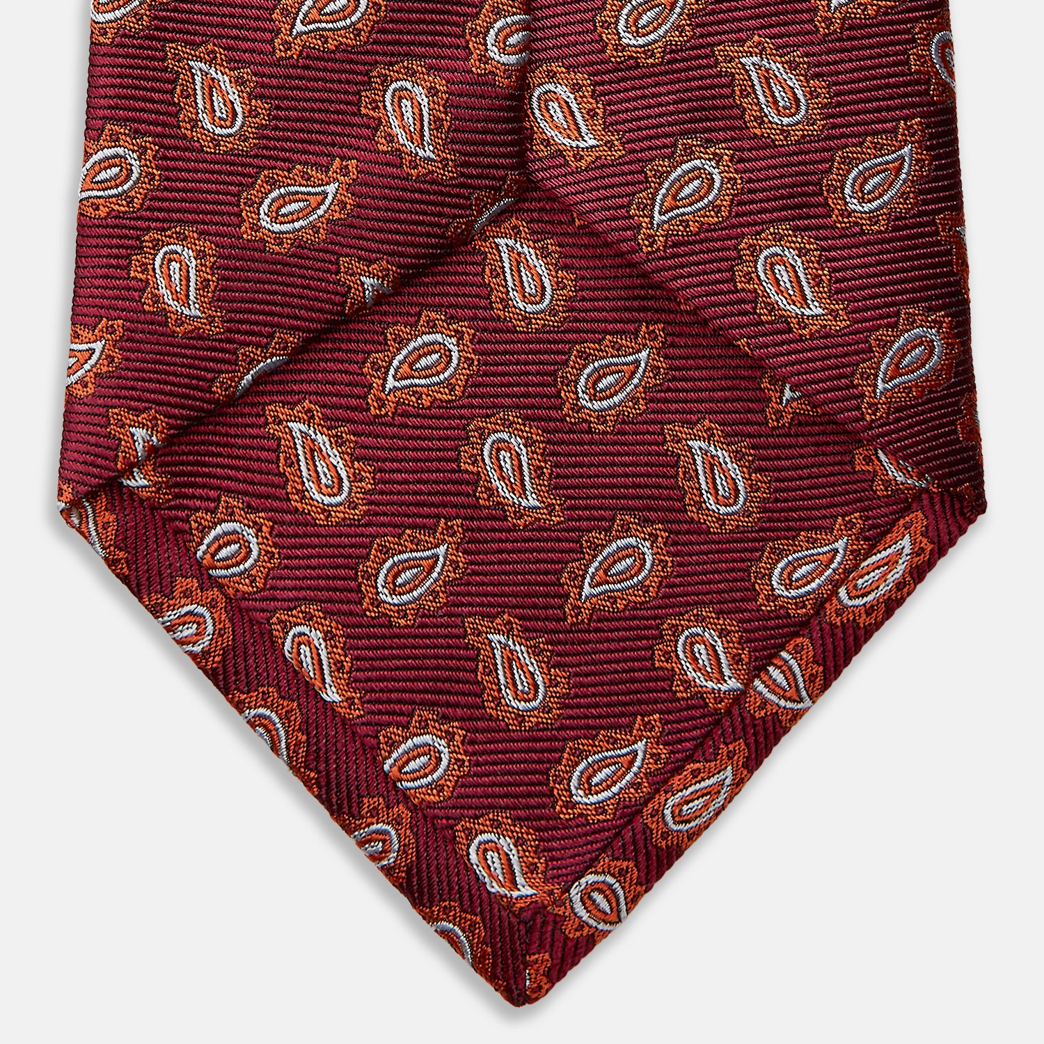 View 4 of product The Turnbull & Asser Red Abstract Paisley Silk Tie features bold orange and white paisley patterns on rich red silk—a stylish choice for fans of classic tailoring.