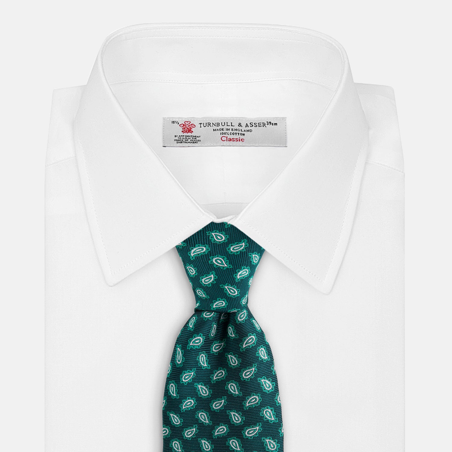 View 2 of product The Turnbull & Asser Green Abstract Paisley Silk Tie features a repeating light green paisley pattern on dark green silk, shown rolled up against a white background—a refined men’s accessory for making a statement.