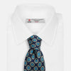 View 2 of product A rolled Navy Floral Geometric Tie by Turnbull & Asser, shown on a light background with light blue and white geometric floral motifs—a refined, stylish accessory.