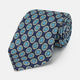 A rolled Navy Floral Geometric Tie by Turnbull & Asser, shown on a light background with light blue and white geometric floral motifs—a refined, stylish accessory.