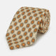 A cream floral geometric tie by Turnbull & Asser, rolled with the pointed end forward, is displayed on a white background.