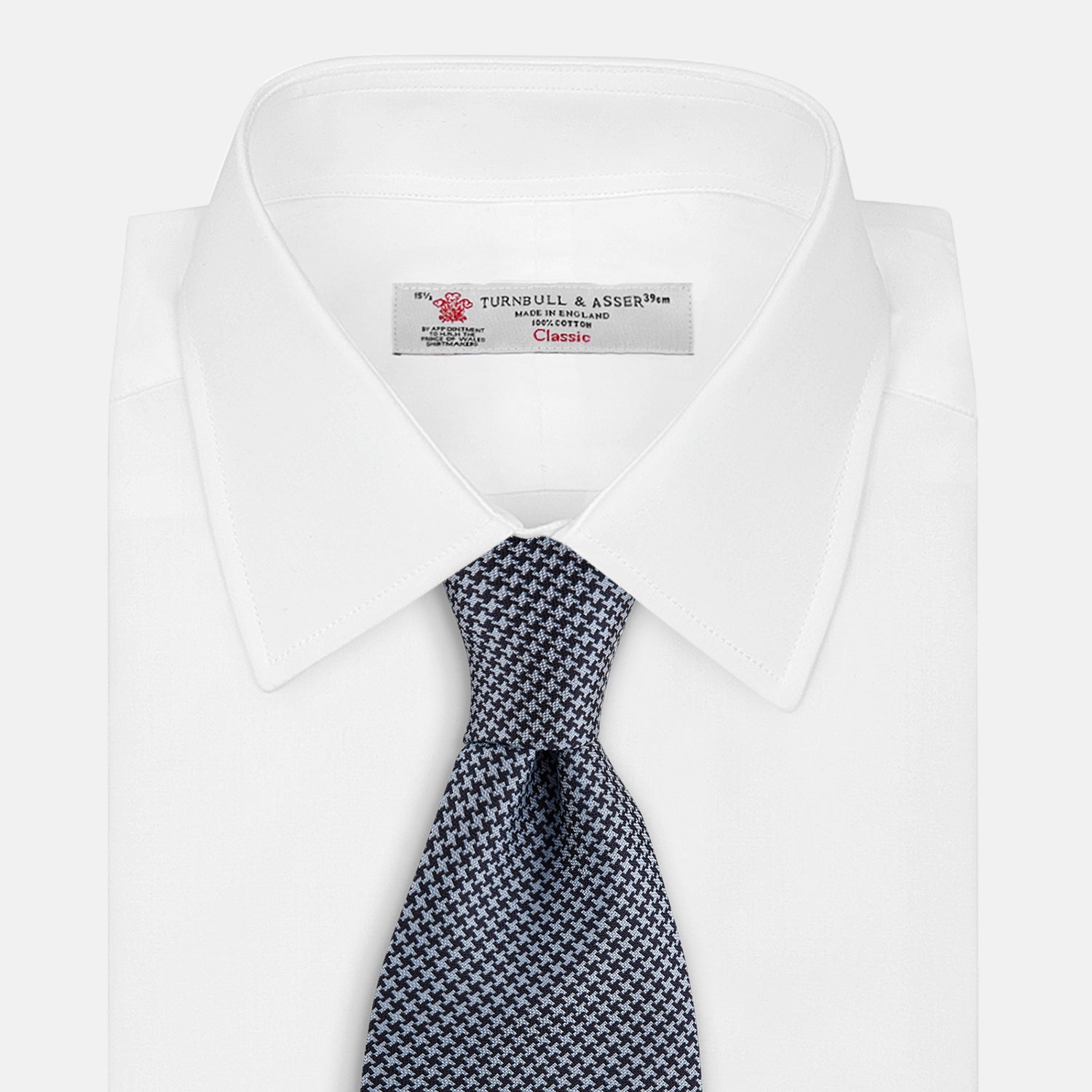 View 2 of product The Turnbull & Asser Blue Houndstooth Silk Tie, shown rolled on a plain white background, adds a refined touch to any sophisticated wardrobe.