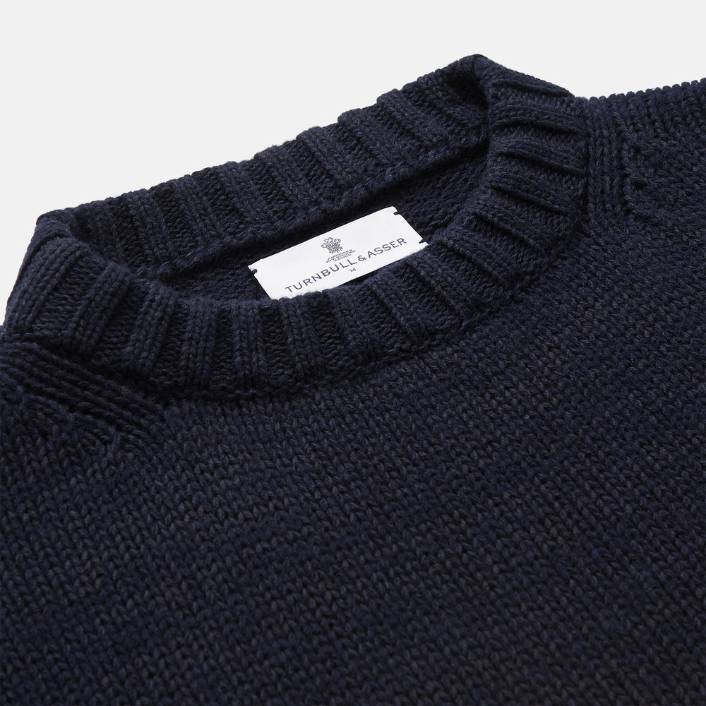 A man stands in the Turnbull & Asser Navy Lewis Guernsey Knitted Jumper.